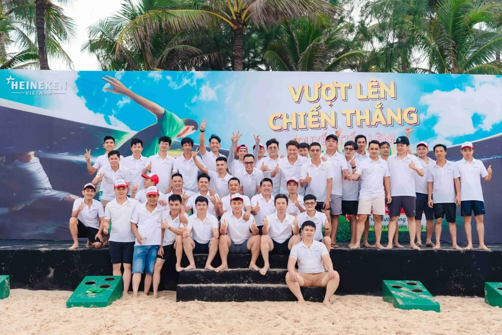 Đội ngũ Heineken Việt Nam chụp ảnh lưu niệm trước backdrop Vượt lên chiến thắng tại Mũi Né